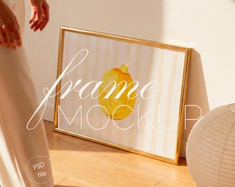 Horizontal Gold Frame Mockup with Person, Sunlit Living Room, 4:3 Poster Display (PSD File)