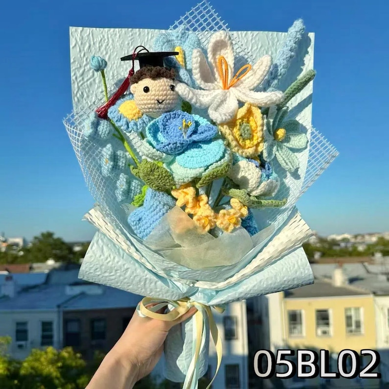 Crochet graduation bouquet in blue and white shades with crochet daisies and delicate leaves.