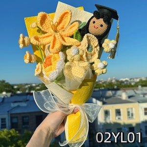 Crochet graduation bouquet in soft yellow tones with crochet lilies and small white flowers.