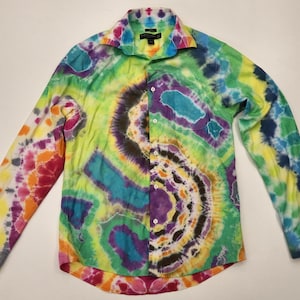 May include: A long-sleeved button-down shirt with a vibrant tie-dye pattern. The shirt features a kaleidoscope of colors, including green, yellow, purple, blue, and pink. The collar and cuffs are also tie-dyed, creating a bold and eye-catching design.