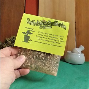 Peut inclure: Un sachet jaune et vert d'herbes et d'&eacute;pices s&eacute;ch&eacute;es &eacute;tiquet&eacute; "Garlic & Herb Combination Backyard Patch". L'&eacute;tiquette comprend &eacute;galement le texte "Create your own herbal garlic bread, saute vegetables, craft bruschette or a multitude of other Mediterranean compliments. Contains: garlic, basil, parsley, paprika, black pepper."