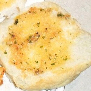 Peut inclure: Gros plan sur un pain rond blanc garni de beurre fondu et d'herbes. Le pain est l&eacute;g&egrave;rement dor&eacute; et a une texture croustillante.