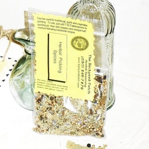 May include: A yellow and white label with the text "The Backyard Patch Herbal Seasoning (630) 248-7978 www.backyardpatch.com" and "Herbal Pickling Spices" on a clear plastic bag filled with dried herbs and spices.