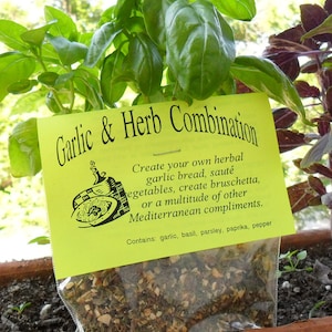 Peut inclure: Un sachet jaune de m&eacute;lange d'assaisonnement &agrave; l'ail et aux herbes s&eacute;ch&eacute;es. L'&eacute;tiquette indique "Garlic & Herb Combination" et comprend des instructions pour utiliser le m&eacute;lange pour cr&eacute;er des plats comme du pain &agrave; l'ail, des bruschetta et des l&eacute;gumes saut&eacute;s. L'&eacute;tiquette indique &eacute;galement les ingr&eacute;dients&nbsp;: ail, basilic, persil, paprika et poivre.