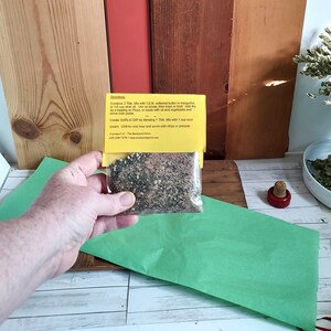 Peut inclure: Un petit sachet jaune de m&eacute;lange d'assaisonnement pour trempette &agrave; l'ail. Le sachet est &eacute;tiquet&eacute; avec des instructions pour faire une trempette &agrave; l'ail, notamment en combinant 2 cuill&egrave;res &agrave; soupe du m&eacute;lange avec 1/2 lb de beurre ou de margarine ramolli, 1/2 tasse de cr&egrave;me sure et 1 cuill&egrave;re &agrave; soupe de jus de citron. Le sachet comprend &eacute;galement le texte "The Backyard Patch".