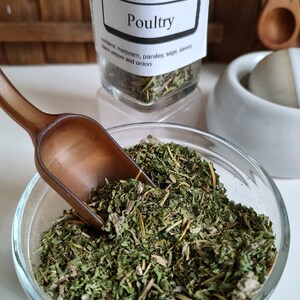 Pu&ograve; includere: Un barattolo di vetro pieno di erbe secche etichettato "Poultry" con il testo "Backyard Patch Herbs Herbal Seasoning 630-248-7278 www.backyardpatch.com" e "contains marjoram, parsley, sage, savory, black pepper and onion".