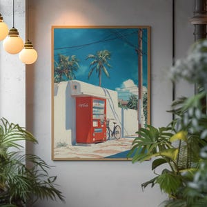 May include: A framed art print depicting a red Coca-Cola vending machine, palm trees, and a bicycle against a blue sky. The artwork has a retro style. The print is displayed on a neutral wall, creating a striking contrast with the vibrant colours.
