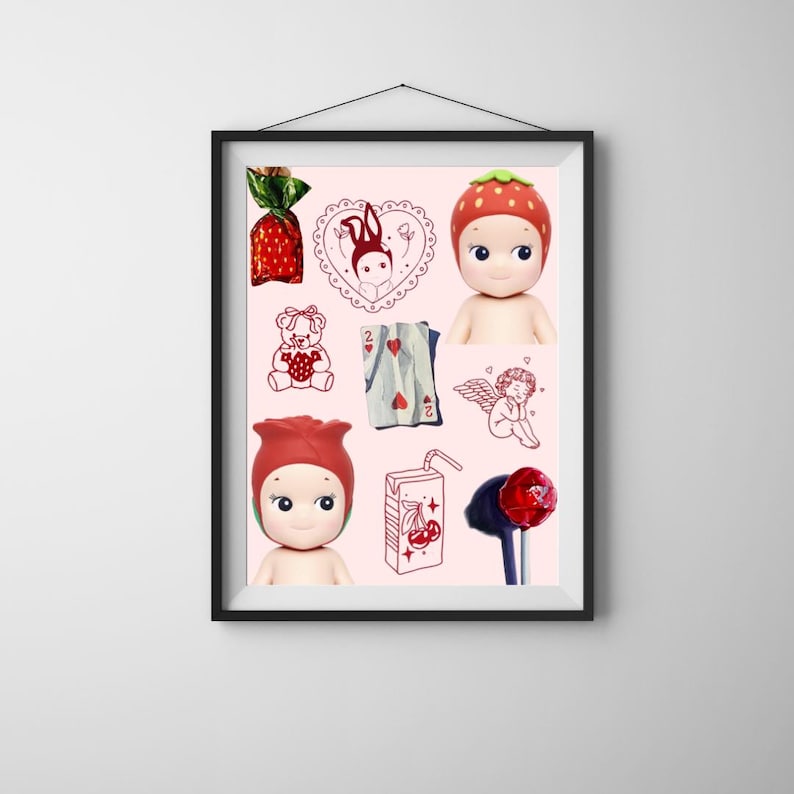 May include: A framed print featuring a collection of whimsical illustrations and doll figures on a pink background. The artwork includes a strawberry-themed doll, a teddy bear, playing cards, and a cherry juice box. The overall aesthetic is cute and playful.