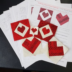 Könnte beinhalten: Ein Set aus sieben roten und weißen herzförmigen Quiltblöcken in den Größen 2,5 bis 17,8 cm. Die Blöcke werden mit der Foundation Paper Piecing (FPP)-Technik hergestellt und sind für Quiltprojekte konzipiert.