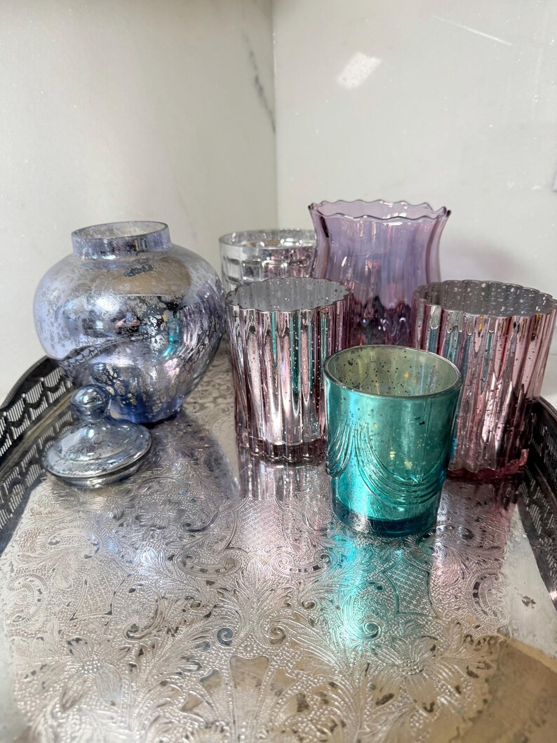Peut inclure: Une tasse en c&eacute;ramique blanche avec une anse noire et le texte "But First, Coffee" en gras noir. La tasse est pos&eacute;e sur un fond flou. La tasse mesure environ 10 cm de hauteur.