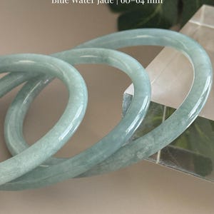 May include: A set of three ceramic mugs with a speckled, matte finish. The mugs are in shades of cream, light gray, and dark gray. Each mug has a simple, minimalist design and a rounded handle.