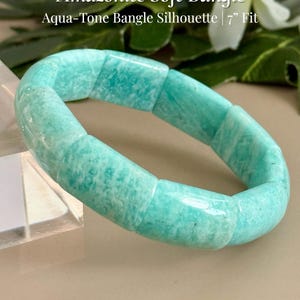 May include: An Amazonite bangle bracelet featuring smooth, rectangular aqua-toned stone segments. The text on the image reads Amazonite Soft Bangle, Aqua-Tone Bangle Silhouette | 7" Fit, and AmorGemsBoutique™. The bracelet has a 7-inch fit.