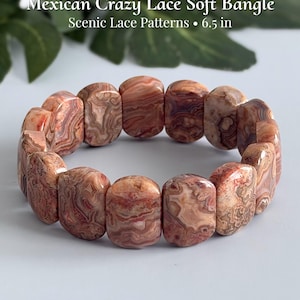 May include: A Mexican Crazy Lace soft bangle bracelet featuring polished, rectangular stone beads with intricate, swirling red, brown, and cream patterns. The text on the image reads Mexican Crazy Lace Soft Bangle Scenic Lace Patterns 6.5 in.