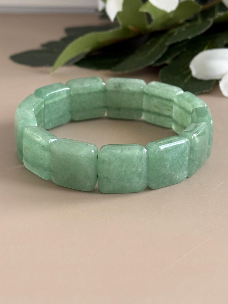 Pu&ograve; includere: Un braccialetto verde chiaro composto da pietre rettangolari lucide. Il braccialetto &egrave; di un colore verde tenue e sembra essere fatto di una pietra naturale. Il braccialetto ha una circonferenza di circa 18 cm.