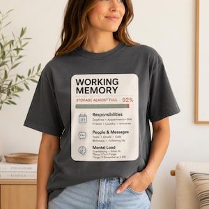 May include: A charcoal gray t-shirt featuring a graphic print of a progress bar labeled WORKING MEMORY, STORAGE ALMOST FULL, and 92%. Below are icons and text for Responsibilities, People & Messages, and Mental Load with various sub-tasks.