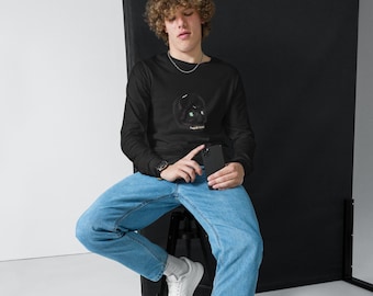Peut inclure: Un t-shirt noir à manches longues avec un motif de crâne aux yeux verts et le mot "malicious" en dessous. Il est associé à un jean bleu clair et des baskets blanches. La personne tient un smartphone noir.