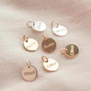 May include: A collection of seven gold and silver personalised name tags with various names engraved on them, including Oliver, William, Noah, Charlotte, Emma, Olivia, and Jane.