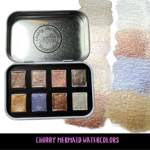 May include: A set of three ceramic mugs with a speckled, cream-colored glaze. Each mug features a different hand-painted floral design in shades of blue, green, and yellow. The mugs have a simple, rounded shape and a comfortable handle.