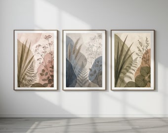 May include: A set of three framed wall art prints featuring botanical illustrations of ferns, grasses, and leaves layered over abstract shapes in muted tones of beige, sage green, dusty rose, and slate blue, enclosed in thin brown frames.