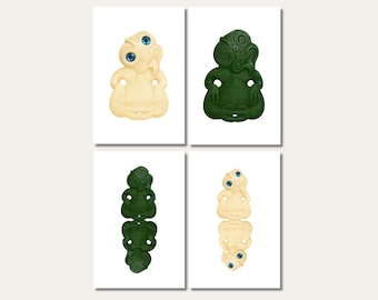 May include: Four art prints featuring stylized tiki figures. Two prints show a cream-colored tiki with blue eyes, while the other two feature a dark green tiki. The tiki figures have intricate carved details and are set against a white background.