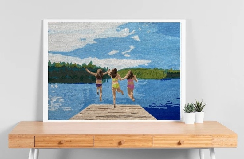 May include: Three people jump off a wooden dock into a lake. The lake is blue and the sky is light blue with white clouds. The people are wearing swimsuits and are jumping with their arms outstretched.