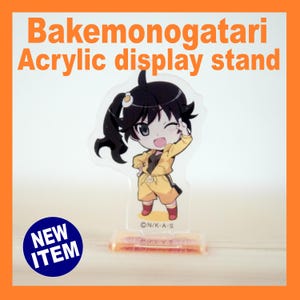 May include: Clear acrylic display stand featuring a Bakemonogatari character in a yellow outfit. The stand has a rectangular base and the text "Bakemonogatari Acrylic display stand" is printed at the top. A "NEW ITEM" sticker is on the bottom left.