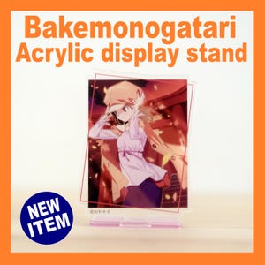 May include: A clear acrylic display stand featuring a colorful anime illustration. The stand has a rectangular design with a pink base and a printed image of a character from Bakemonogatari. The text "Bakemonogatari Acrylic display stand" is printed at the top.
