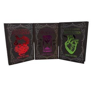 May include: Three hardcover books with dark covers. The titles are "Insatiable", "Voracious", and "Restitution". Each book features a unique graphic in vibrant colors: a red skull, a pink hourglass, and a green anatomical heart. The author's name, Leigh Rivers, is printed on each book.