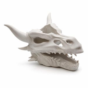 Side profile view of the dragon skull planter emphasizing horns, eye sockets, and bone contours.
