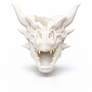 Front-facing view of a dragon skull head planter with open mouth, showing horn details and sculpted teeth.
