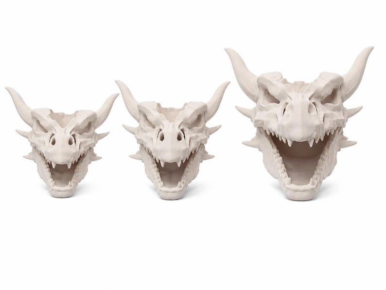 Three dragon skull planters in small, medium, and large sizes displayed front-facing with open mouths and horned details on a white background.