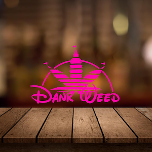 Może przedstawiać: Jasnoróżowa grafika przedstawiająca stylizowaną koronę z liści konopi z napisem "Dank Weed". Projekt jest parodią znanego logo. Obraz jest umieszczony na rozmytym tle.