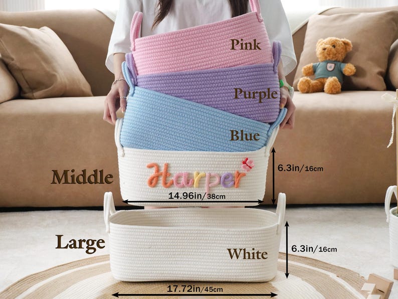 May include: A stack of four rectangular rope baskets in pink, purple, blue, and white. The white basket has the name "Harper" embroidered on it. The baskets are 14.96 inches (38cm) and 17.72 inches (45cm) wide, and 6.3 inches (16cm) high.