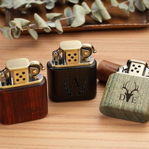 May include: A white ceramic mug with a black handle and the text "But First, Coffee" in a bold, black font. The mug is set against a blurred background, suggesting a cozy setting.