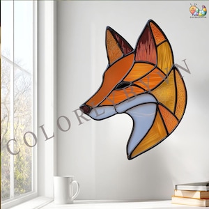 May include: Stained glass fox head in shades of orange, yellow, and white, with a black outline. The fox is depicted in profile, with a detailed mosaic-like design. The artwork is mounted on a white wall, with the text "COLORLYBYVN" visible.