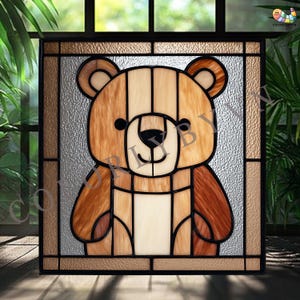 May include: Stained glass panel featuring a teddy bear design. The bear is rendered in shades of brown, beige, and cream, with black accents for the eyes and nose. The panel is framed in a dark brown border, creating a decorative piece.