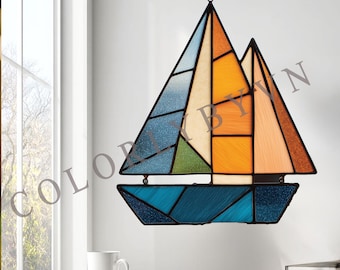 Puede incluir: Un vitral de un velero con paneles azules, verdes, naranjas y beige. El velero tiene un marco oscuro y está colgado en una pared blanca. El texto "COLORLYBYVN" es visible en la imagen.