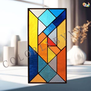 Könnte beinhalten: Eine Glasmalerei mit geometrischem Design. Das Panel zeigt eine Vielzahl von Farben, darunter Gelb, Blau, Orange und Grau, angeordnet in einem rechteckigen Rahmen. Der Text "COLORLIBY" ist auf der linken Seite des Panels sichtbar.