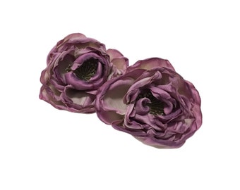 May include: Two purple silk fabric flowers with ruffled petals. The flowers are closed and have a slightly faded appearance.