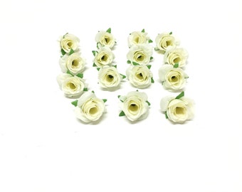 Könnte beinhalten: Eine Sammlung von 18 kleinen, weißen künstlichen Rosen mit grünen Blättern. Die Rosen sind in zwei Reihen auf einem weißen Hintergrund angeordnet.