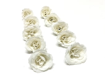 Könnte beinhalten: Ein Set mit 12 weißen Papierblumen, jede mit einem zarten, geschichteten Design. Die Blumen sind in zwei Reihen angeordnet, mit sechs Blumen in jeder Reihe.