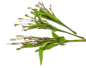 May include: Two bunches of artificial flowers with small pink blossoms and green leaves tied together with a green ribbon.