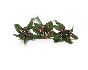 May include: Three sprigs of artificial greenery with pink berries. Each sprig has multiple green leaves and small pink berries.