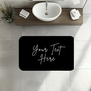 a bathroom with a sink and a black rug