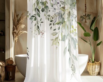 Pode incluir: Cortina de duche branca com um design botânico em aquarela com folhas e caules verdes e cinzentos. A cortina está numa casa de banho com uma banheira branca e um cesto de vime com uma planta.
