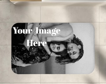 May include: Rectangular bath mat with a black and white image of a couple embracing. The text "Your Image Here" is printed in white on the mat. The mat is placed on a tiled floor.