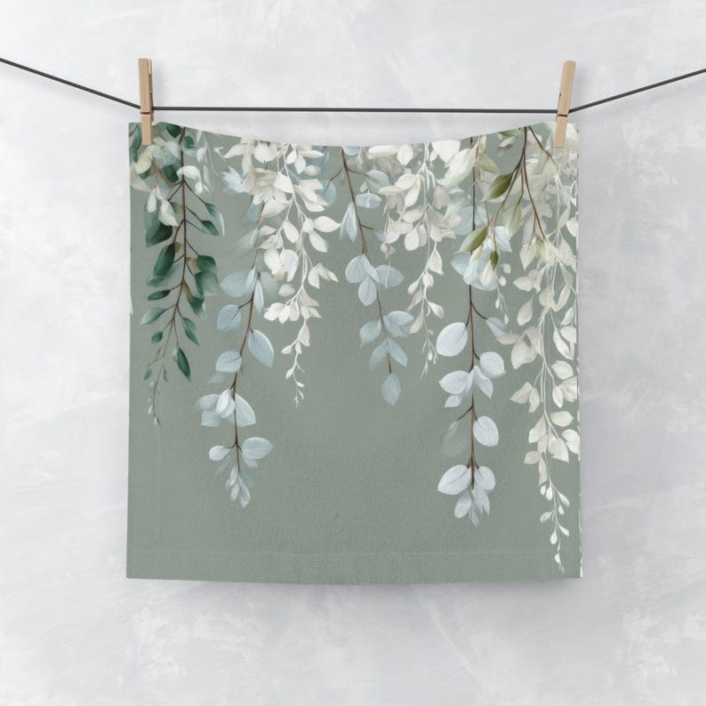A square piece of fabric with a floral pattern hanging on a clothesline.