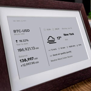 Stock, crypto, forex, ETF & precious metals e-ink live price ticker Brisa Frame rests on a table, encased in a handcrafted wooden frame with soft. The e-ink display shows MSCI ACWI live price (including wallet value), EURUSD currency exchange rate, AAPL stocks price & weather. Designed for slow living and mindful interiors, Brisa blends technology with calm aesthetics, delivering daily information in a serene, non-intrusive way.