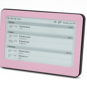 May include: A digital calendar display with a light pink frame and a black border. The screen shows a weekly schedule with entries for Monday, Tuesday, and Wednesday, including times and event titles like Family dinner and Product review.