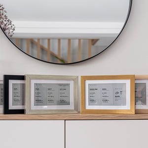Brisa frames in various finishes, elegantly displaying real-time financial data including Bitcoin and crypto prices, stock market tickers, ETF updates, and forex currency rates. The minimalist e-ink dashboard frames show detailed market information clearly and discreetly, making them perfect decorative financial trackers for any modern home or office.